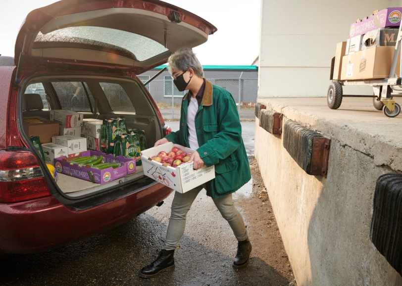 Leftovers Foundation volunteer loading a car with food